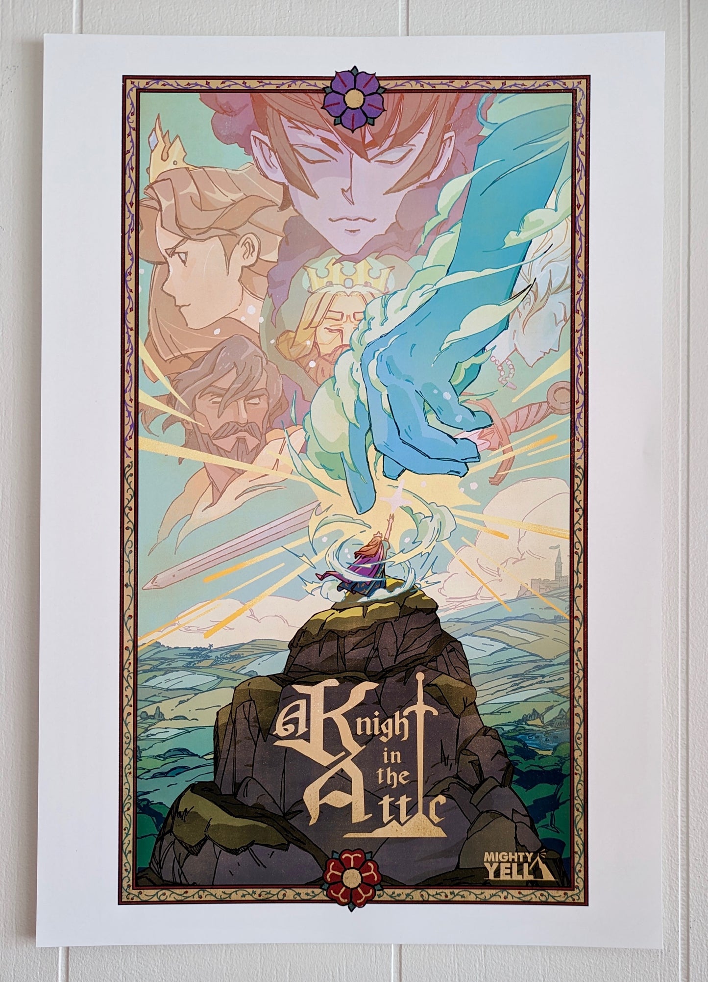 A Poster with Key Art from the game A Knight In The Attic. Featuring Characters faces and a mountain landscape in soft and vibrant blue, yellow, green, brown and peach. A character stands atop a mountain, in front of a large blue hand and a sword. In medieval style font it reads “A Knight In The Attic” and the “I” in attic is a sword. The “Mighty Yell Logo in the bottom right corner. The border is yellow with purple and burgundy flowers and green vines. 